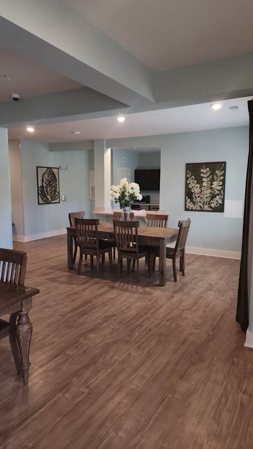 A dining room with a wooden table and chairs.