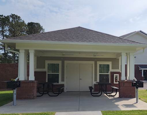 A covered porch with a white door and two windows.