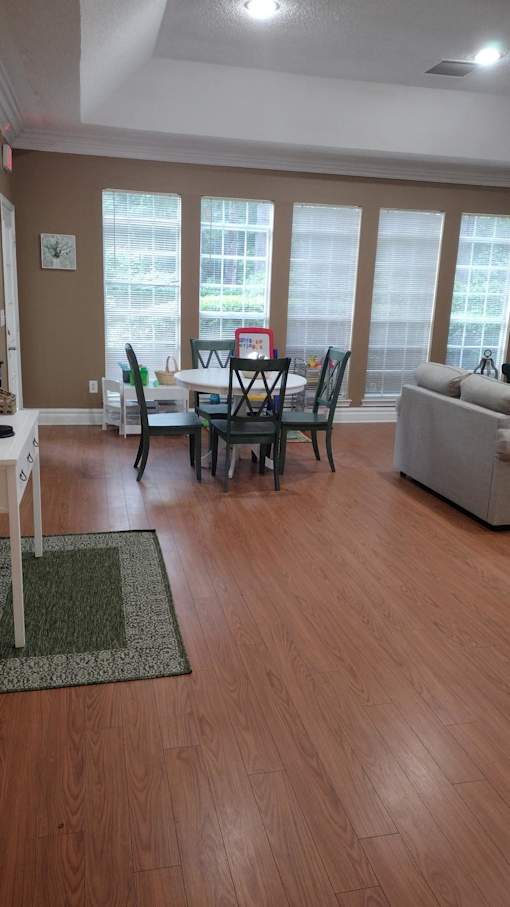 A room with wooden floors and a window with blinds.