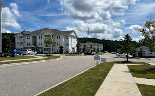 A residential area with apartment buildings and cars parked on the street.