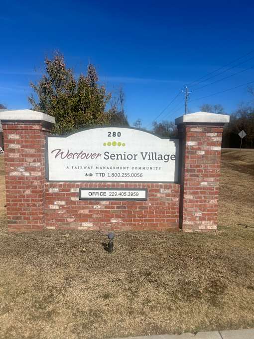 A sign for Westover Senior Village stands in front of a grassy area.