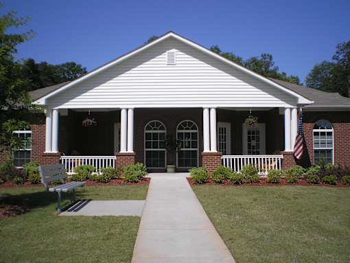 A white building with a bench in front of it.