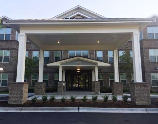 A building with a covered entrance and pillars.
