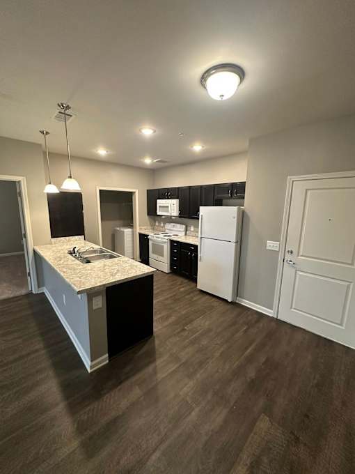 A kitchen with a granite countertop and white appliances.