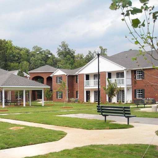 A brick building with a white trim and a covered walkway.