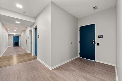 A hallway with a blue door and a sign on the wall.
