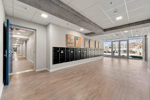A hallway with a row of lockers on the right side.