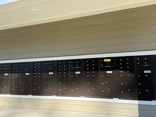 A row of black electrical switchboards are mounted on a wall.