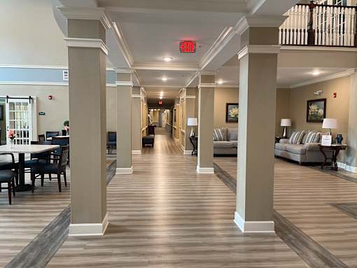 A long hallway with a red exit sign at the end.