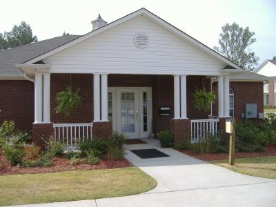 A small house with a white front porch and a grey roof.