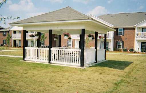 A white porch with a black roof and pillars.