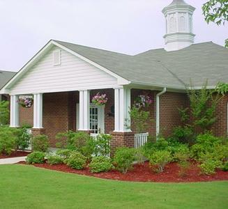 A small house with a white roof and a brick chimney.