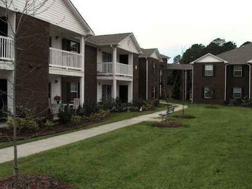 Apartment complex with a small tree in the front.