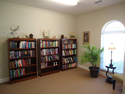 A room with two bookshelves filled with books and a potted plant.