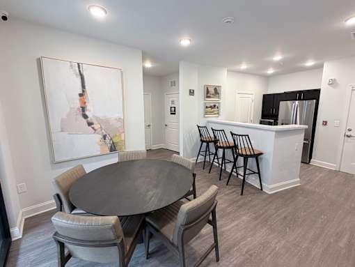 A dining room with a large table and chairs.