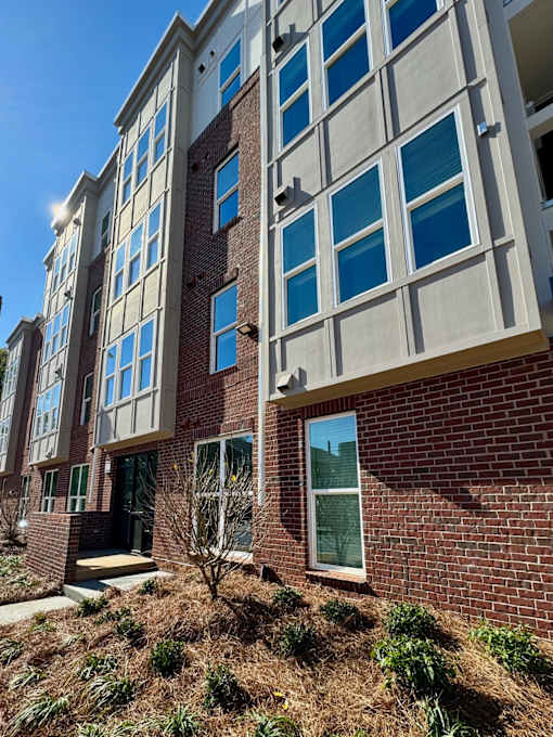 A multi-story building with a brick facade and large windows.