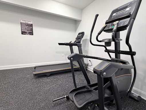 A gym with a treadmill and a stationary bike.