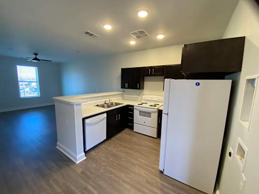 A kitchen with white appliances and a white refrigerator.