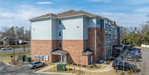 A large brick building with a parking lot in front.