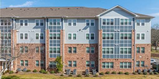 A large multi-story building with a mix of brick and siding exterior.