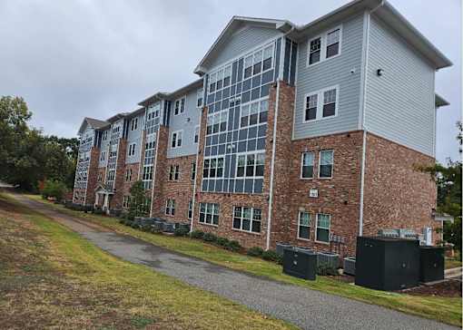 A large multi-story building with a mix of brick and siding exterior.