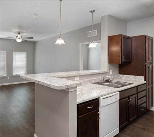 A kitchen with a white countertop and brown cabinets.