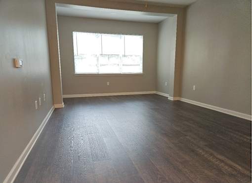 A room with wooden flooring and a window.