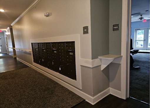 A long white wall with a black panel and a white panel with a black border.