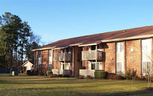 Apartment building with a small house in front.