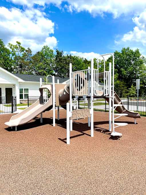 A playground with a slide and a climbing frame.