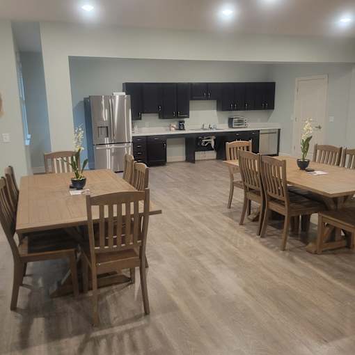 A kitchen with a table and chairs in front of it.