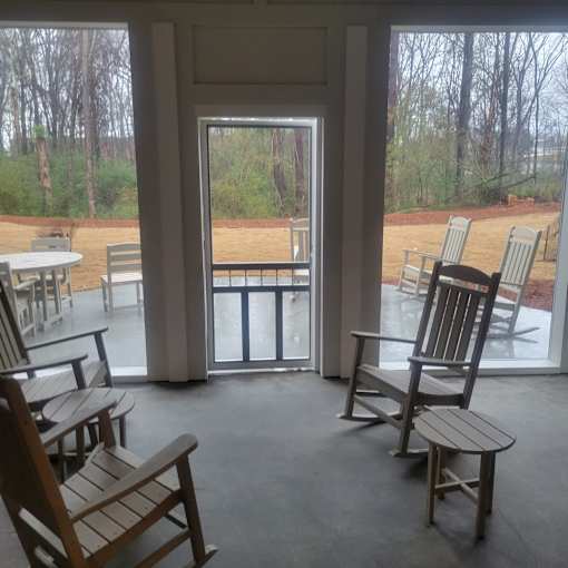 A room with a view of a backyard through a glass door.