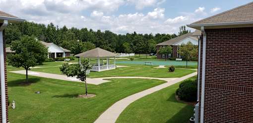 A gazebo is in the middle of a grassy area.