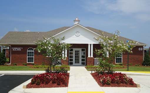 A brick building with a white trim and a sign that says Community Building.