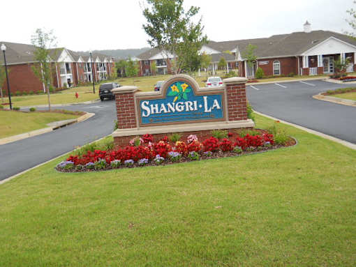 A sign that says Shangri-La in front of some buildings.