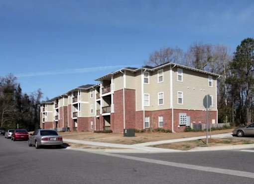 Apartment building with cars parked in front.
