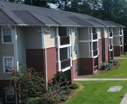 A row of apartment buildings with red brick pillars.