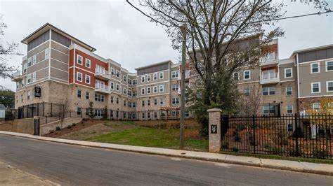 A large apartment complex with a black fence in front.