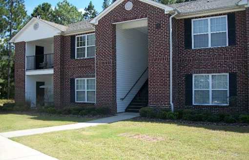 A red brick house with a white door and windows.