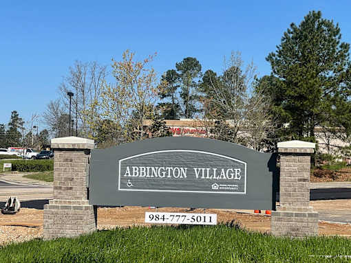 A sign for Abbington Village with a phone number on it.