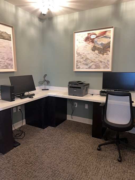 A room with a desk, computer, and chair.