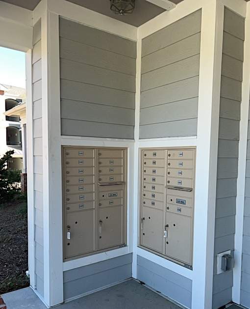 A row of mailboxes are on the side of a building.