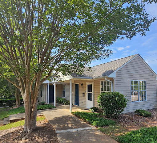A house with a tree in front of it.