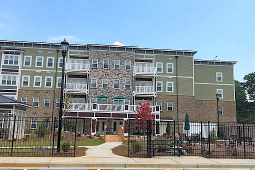 Apartment complex with a black fence in front.