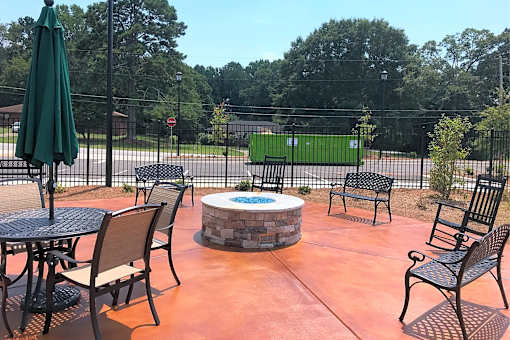 A patio with a table, chairs, and an umbrella.