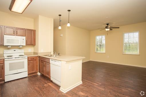 A kitchen with brown cabinets and a white stove top oven.