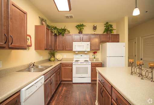 A kitchen with white appliances and wooden cabinets.