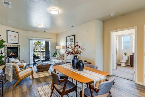 A living room with a fireplace and a dining table.