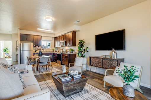 A modern living room with a large flat screen TV mounted on the wall.
