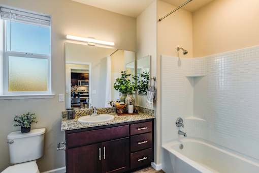 A bathroom with a white tub, sink, and toilet.